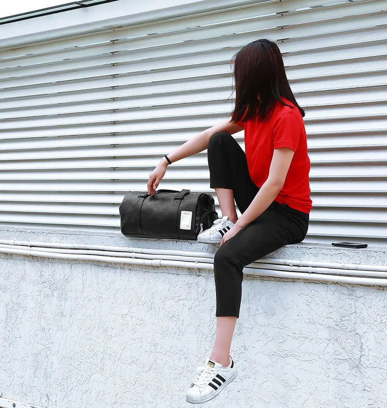 Black waterproof sports bag with diagonal straps and separate shoe compartments in two size options