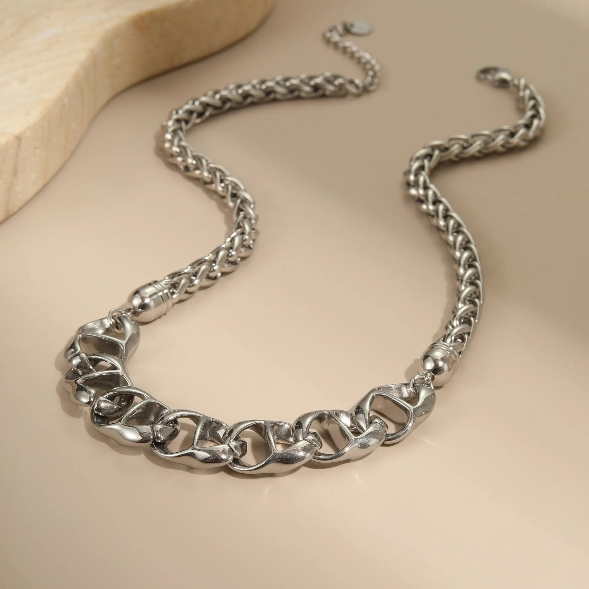 Stainless steel geometric pendant necklace with gold plating on a regular chain.