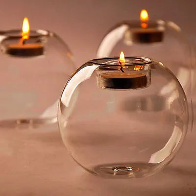 Handmade round hollow glass candle holder in clear glass on wooden surface