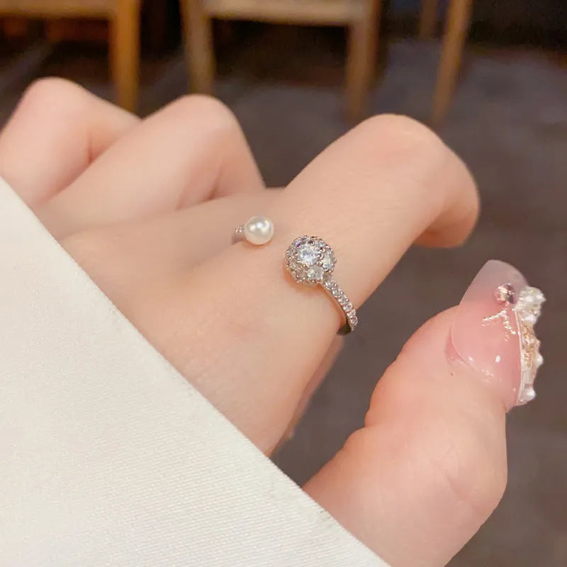 Women's open-end ring with round zircon and pearl detail in gold or silver finish