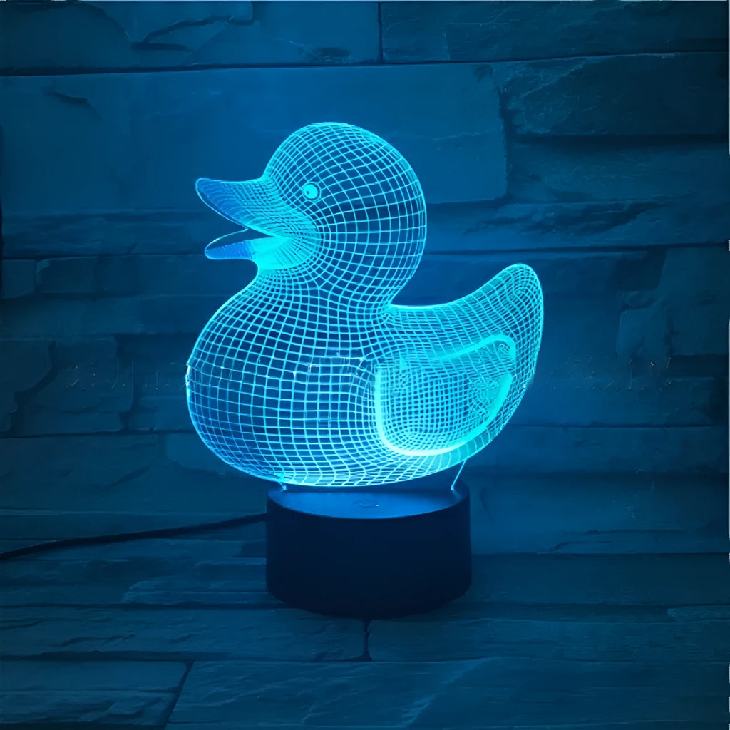 Little yellow duck 3D night light showing seven colour options and remote control on a desk