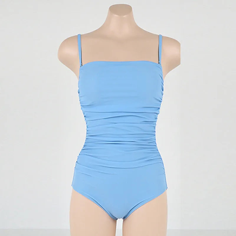 Blue sling style one-piece swimsuit with belly pleating on a mannequin.