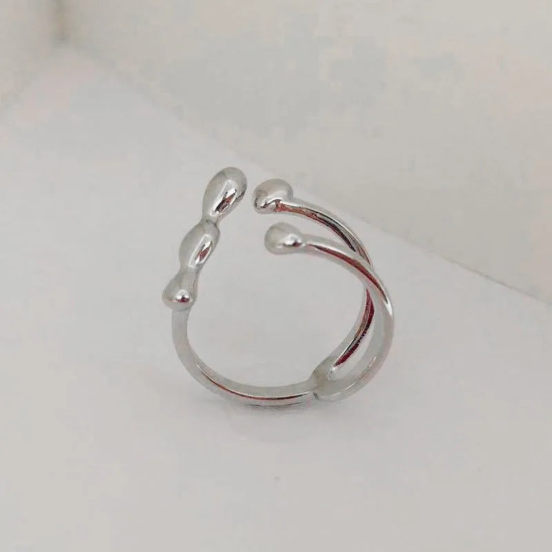 Brass opening ring in gold or silver finish with spherical design details.