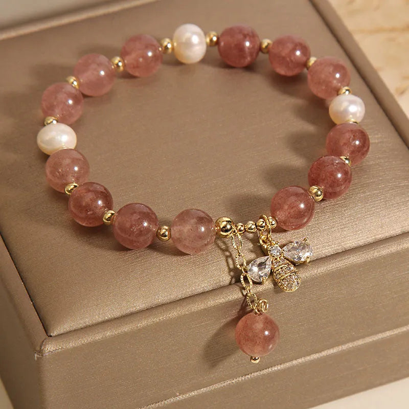 Women's bracelet with freshwater pearls, pink strawberry quartz stones, and a metallic zircon alloy clasp.