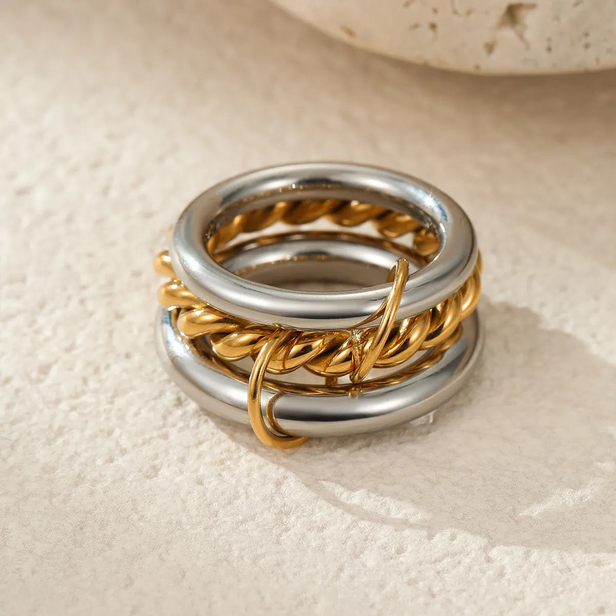 Stacked gold plated stainless steel rings with an exaggerated wide band design, shown in a free size.