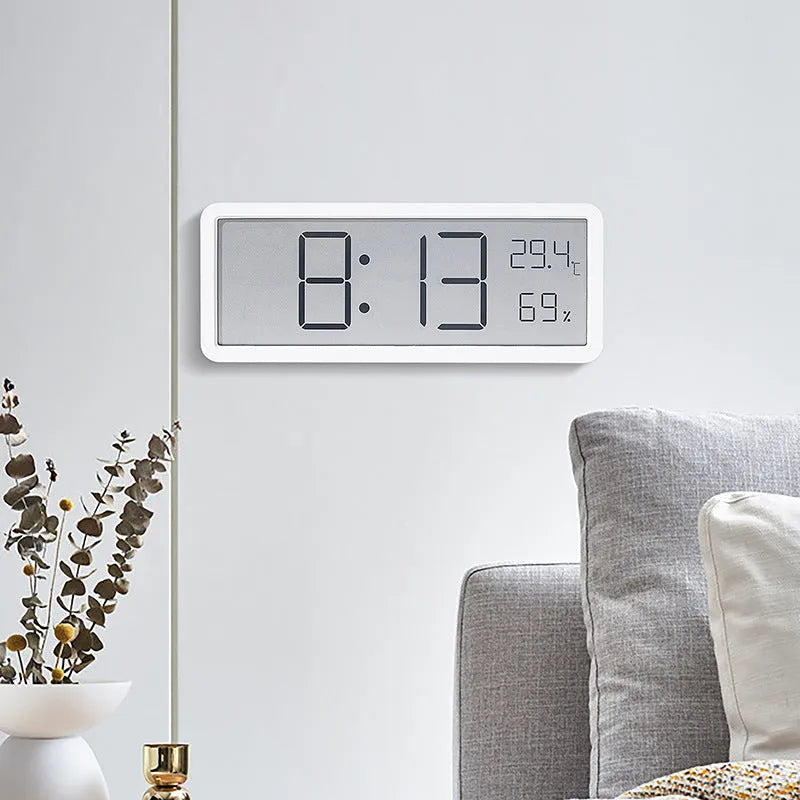 Simple large screen temperature and humidity clock in plastic with Nordic style, black colour, on a desk.