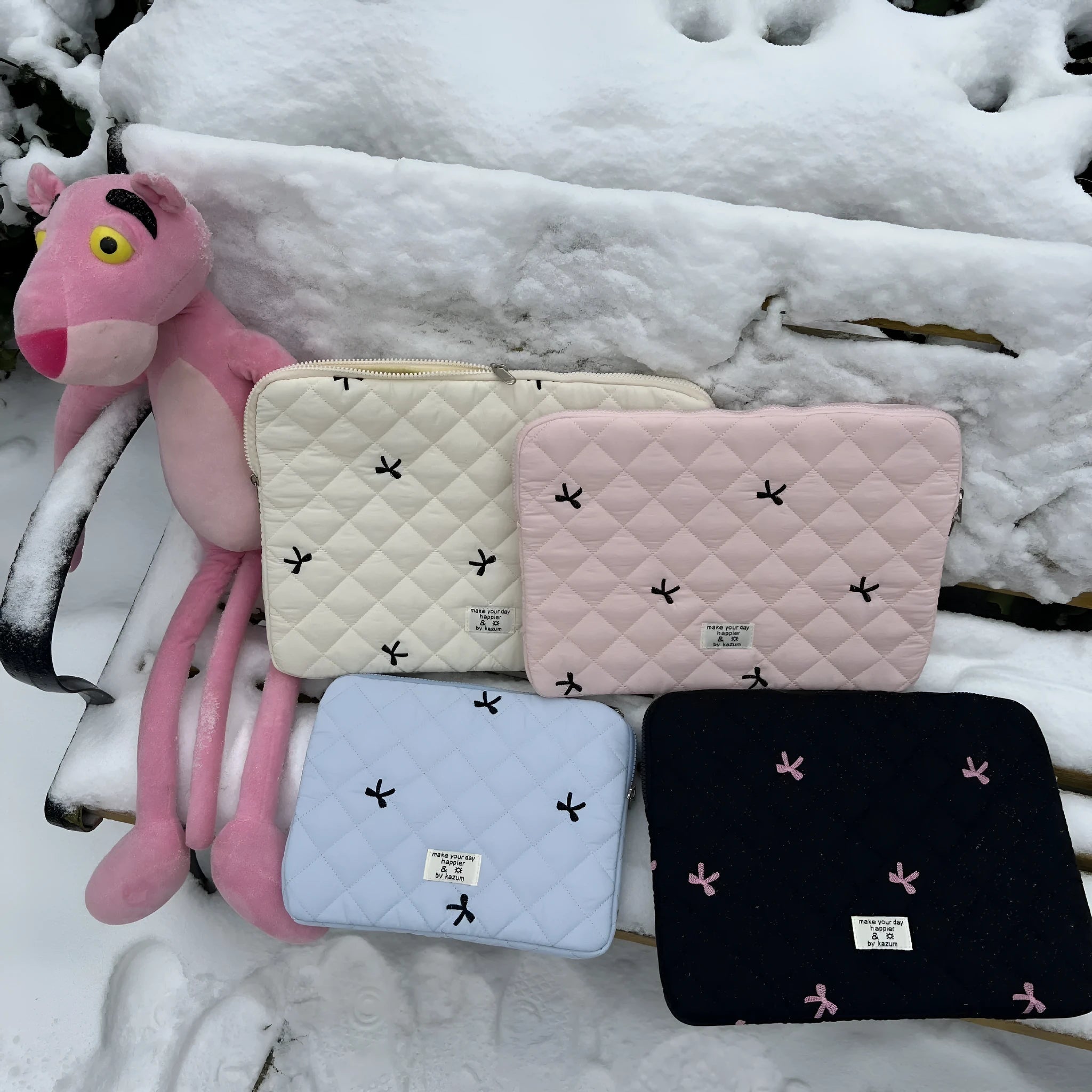 White nylon laptop bag with embroidered rhombus pattern and fabric bow, shown alongside black, light blue, and light pink colour options.