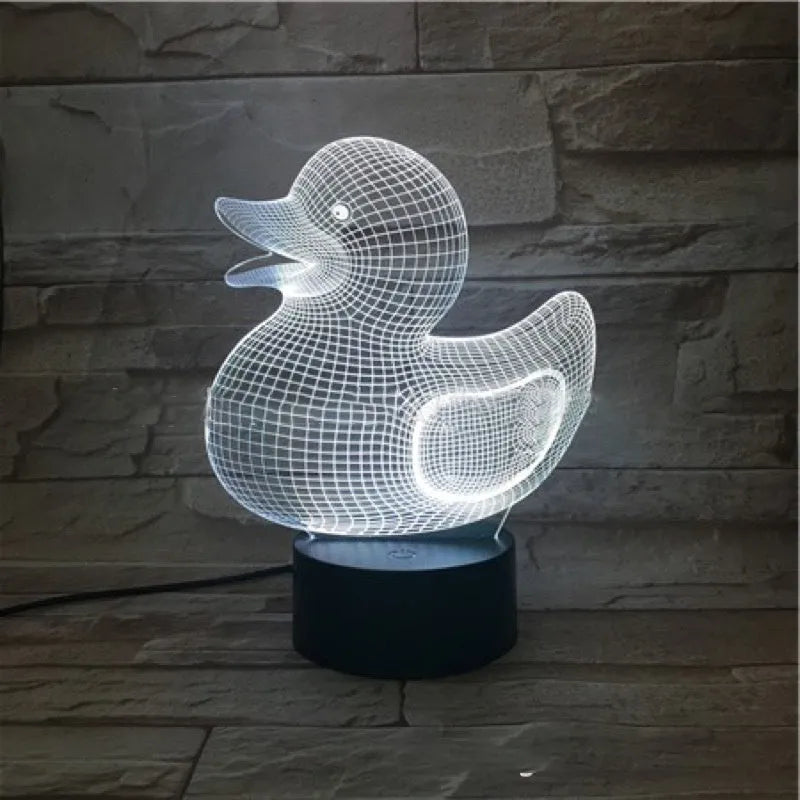 Little yellow duck 3D night light showing seven colour options and remote control on a desk