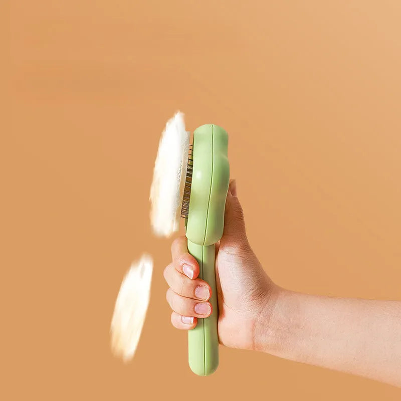 Self-cleaning stainless steel cat comb with green handle, showing 4-row needle design