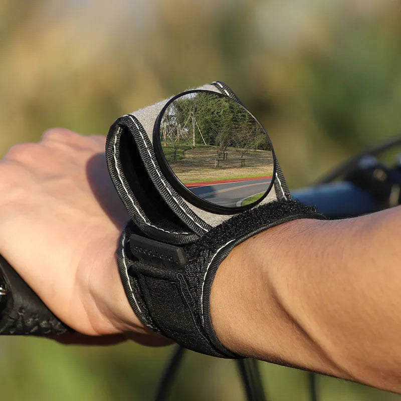 Black nylon wrist-mounted bicycle rear-view mirror with adjustable angle and secure strap for handlebar installation