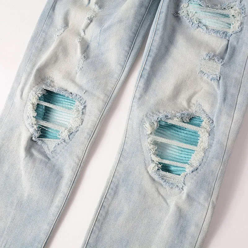 Men's light blue distressed slim fit jeans with five pocket patchwork, enzyme washed, side view