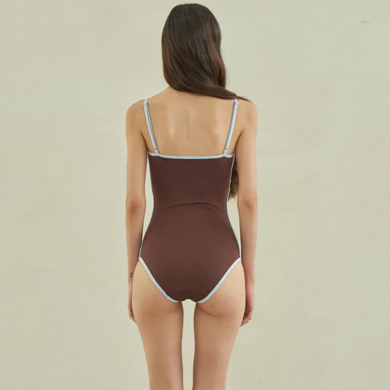 Brown triangle one-piece swimsuit for women on a hanger, showing front design.