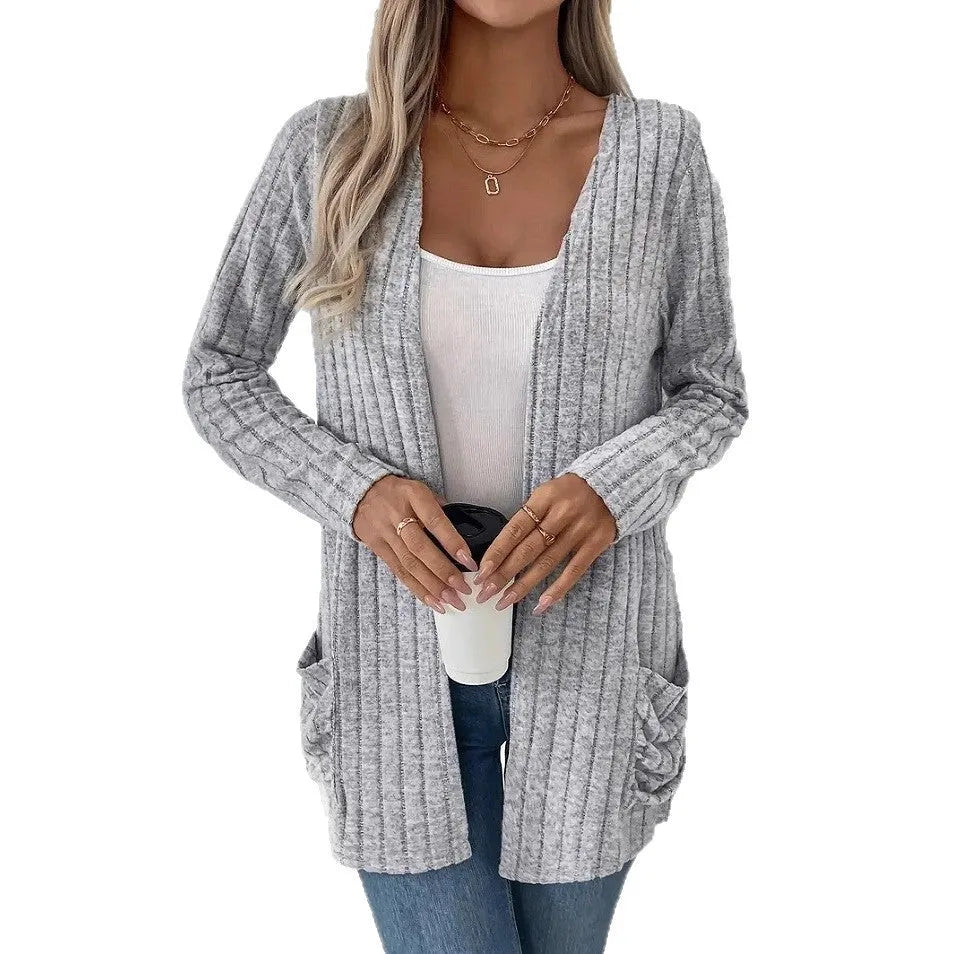 A person wearing a solid grey loose fit long sleeve cardigan with a chest pocket.
