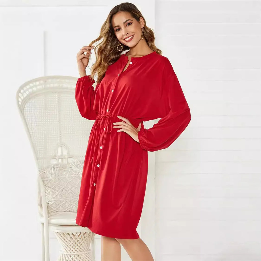 A black women's A-line midi dress with an elastic waist, long sleeves with elastic cuffs, and a detachable cinched belt.