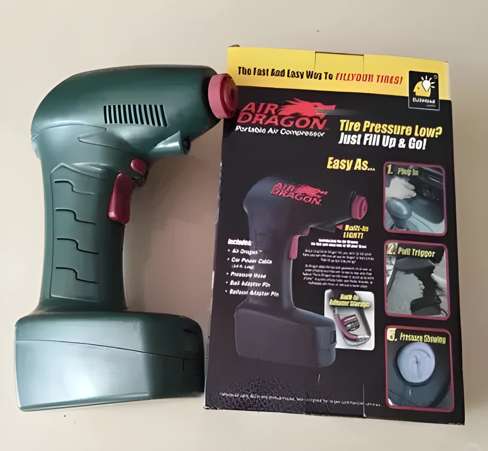 Portable electric car tyre inflator with motor and air pump components on a garage floor.