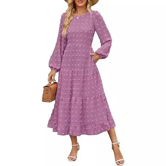A woman wearing a beige high waist long sleeve dress with ruffled sleeves, a round neck, and a solid colour design.