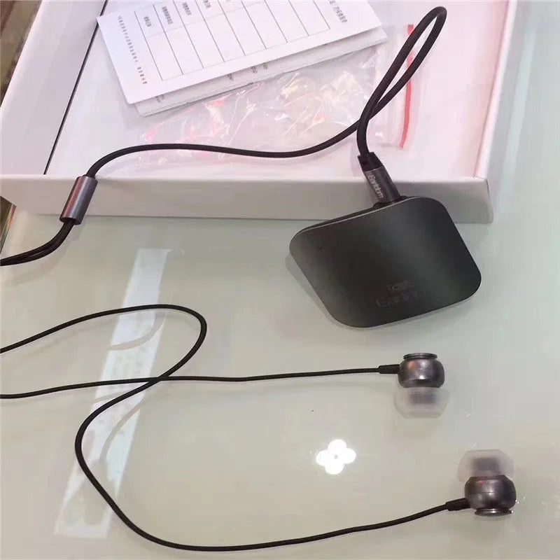 Black Bluetooth lavalier headset with clip, shown alongside packaging.