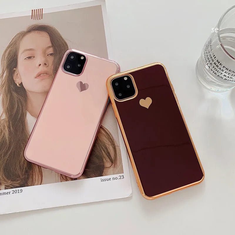 Solid colour TPU back cover case for iPhone on a table, shown in blue, claret, pink, and green.