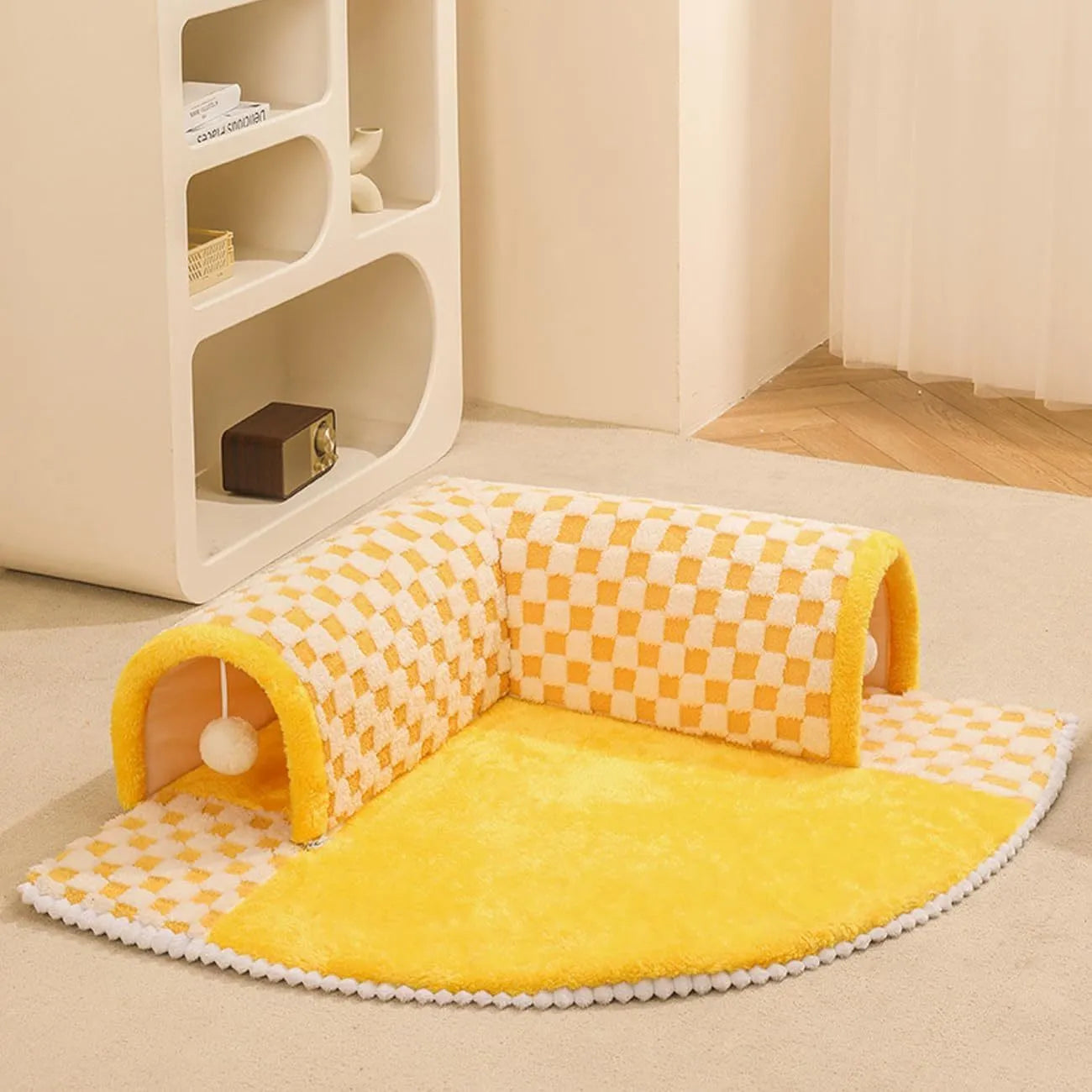 Large fan-shaped plush pet bed with attached tunnel in coffee colour on a wooden floor