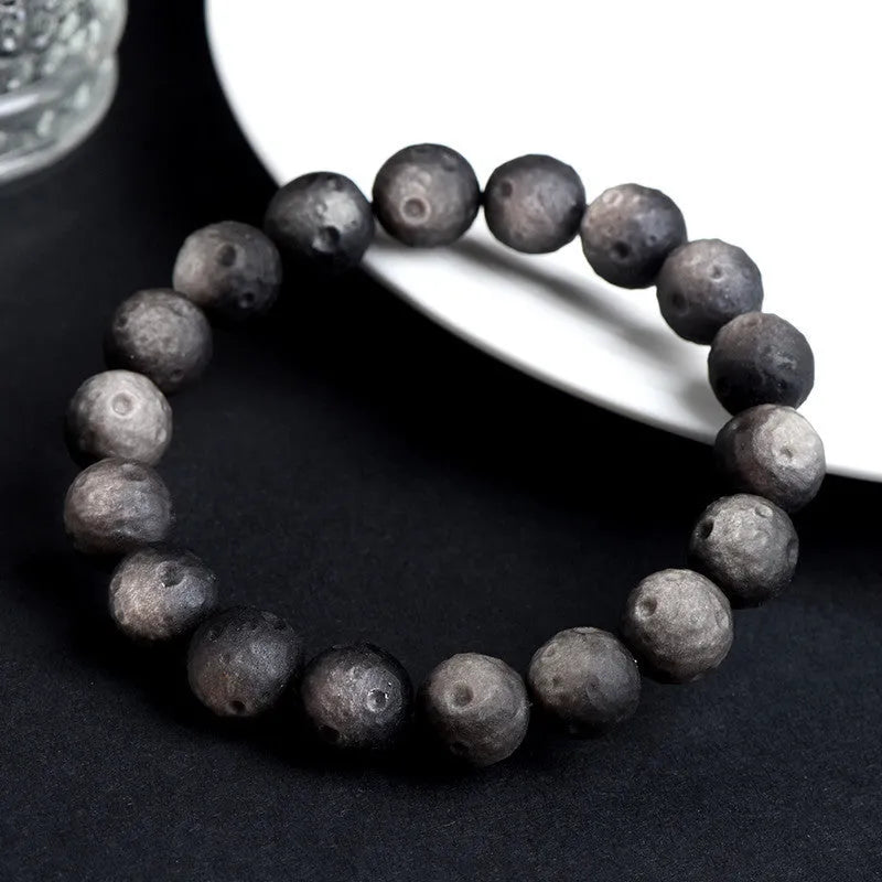 Natural obsidian crater ball bracelet with hand-ground meteorite beads in gold or silver colour options