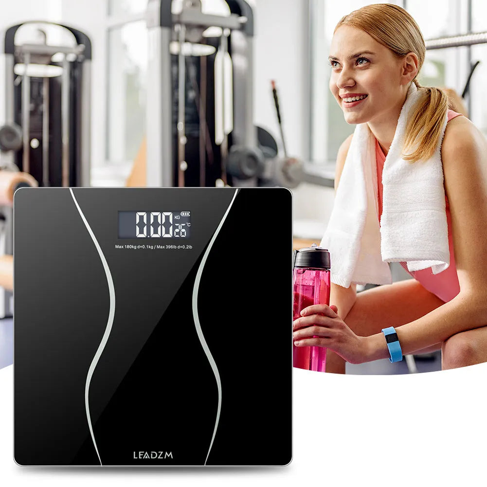 Black electronic household scale with digital display showing weight measurement up to 180kg capacity