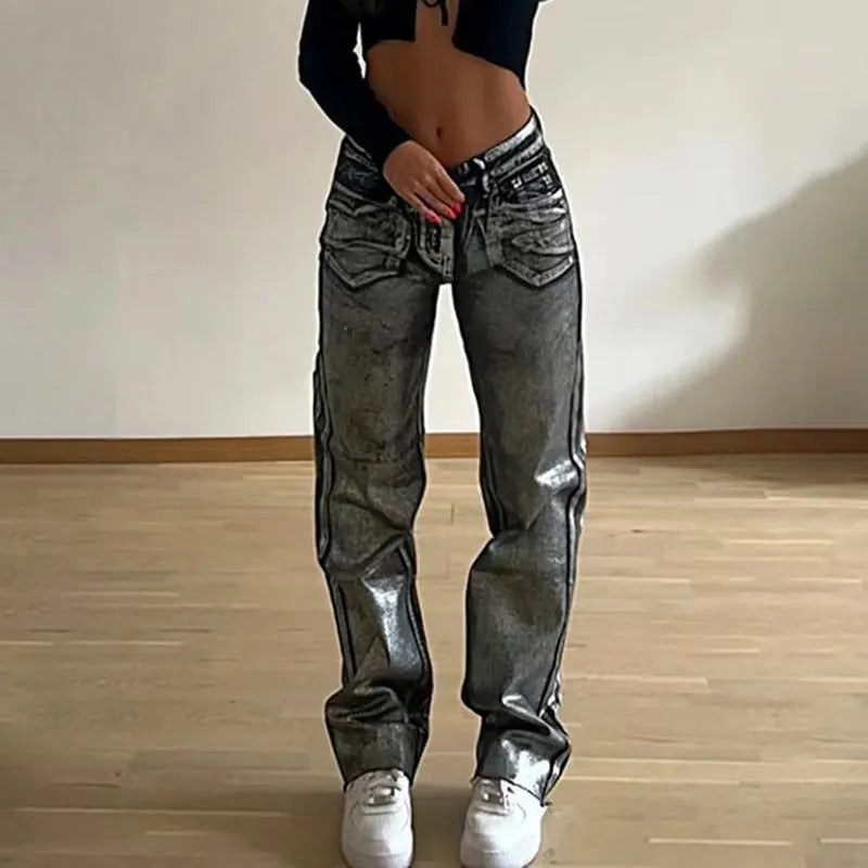 Women's washed blue high-waist straight-leg jeans with silver contrast hardware on a denim background.