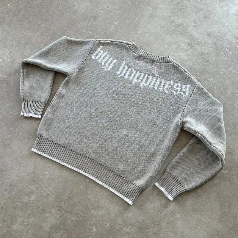 Grey loose-fitting jacquard knit coat on a hanger, showing long sleeves and textured knit pattern.