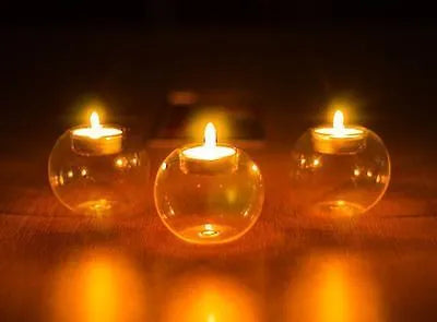 Handmade round hollow glass candle holder in clear glass on wooden surface