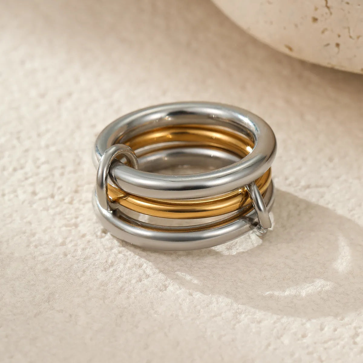 Stacked gold plated stainless steel rings with an exaggerated wide band design, shown in a free size.