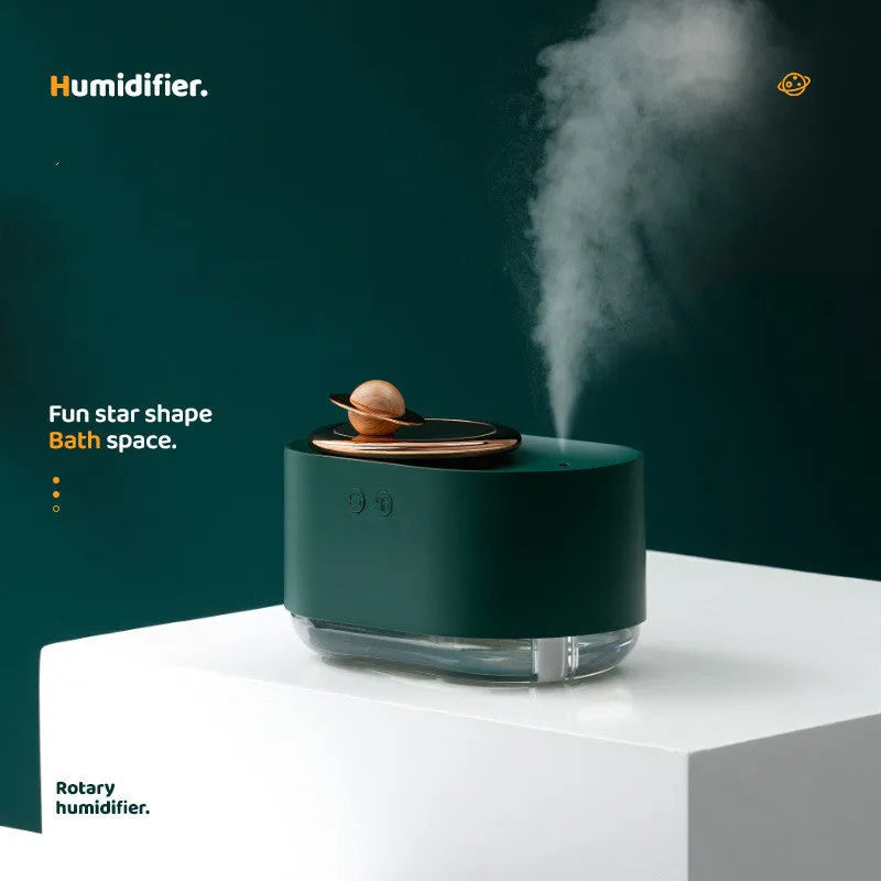 Green rotating planet-shaped car humidifier with night light on a desk next to a USB cable.