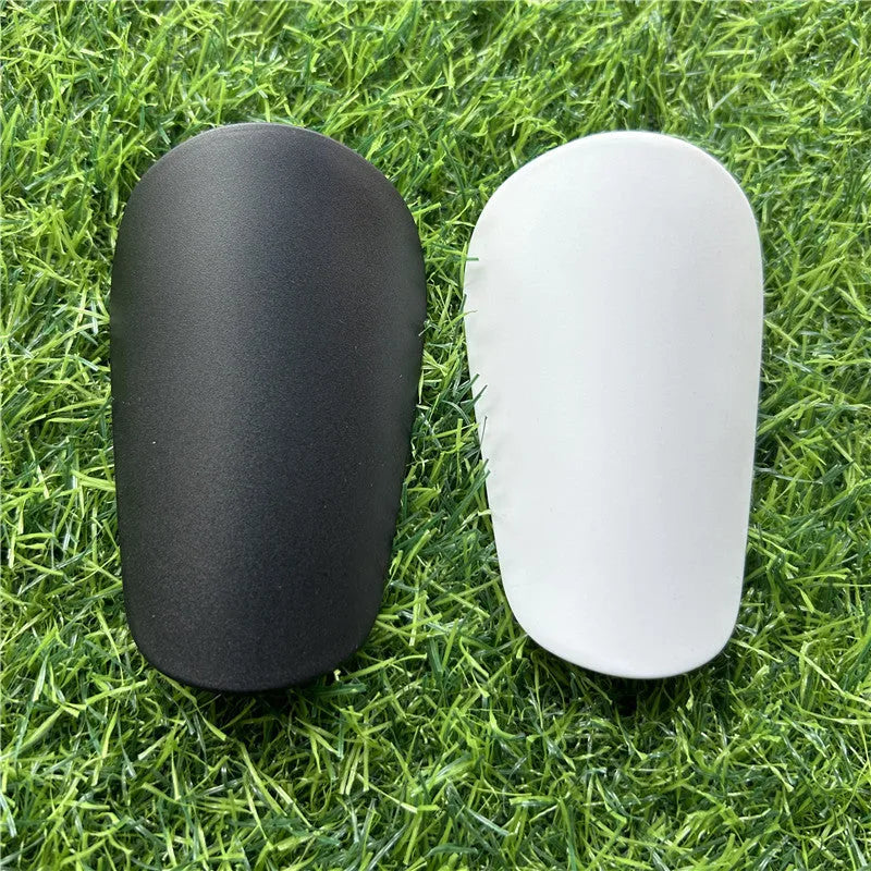 Pair of extra small black plastic football shin guards for junior players.