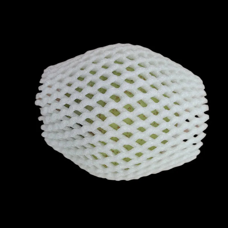 White foam protective net sleeves for fruit in assorted sizes on a table.