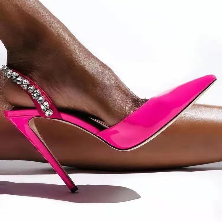 Women's black patent leather pointed toe high heel sandals with side rhinestones and an ankle strap.