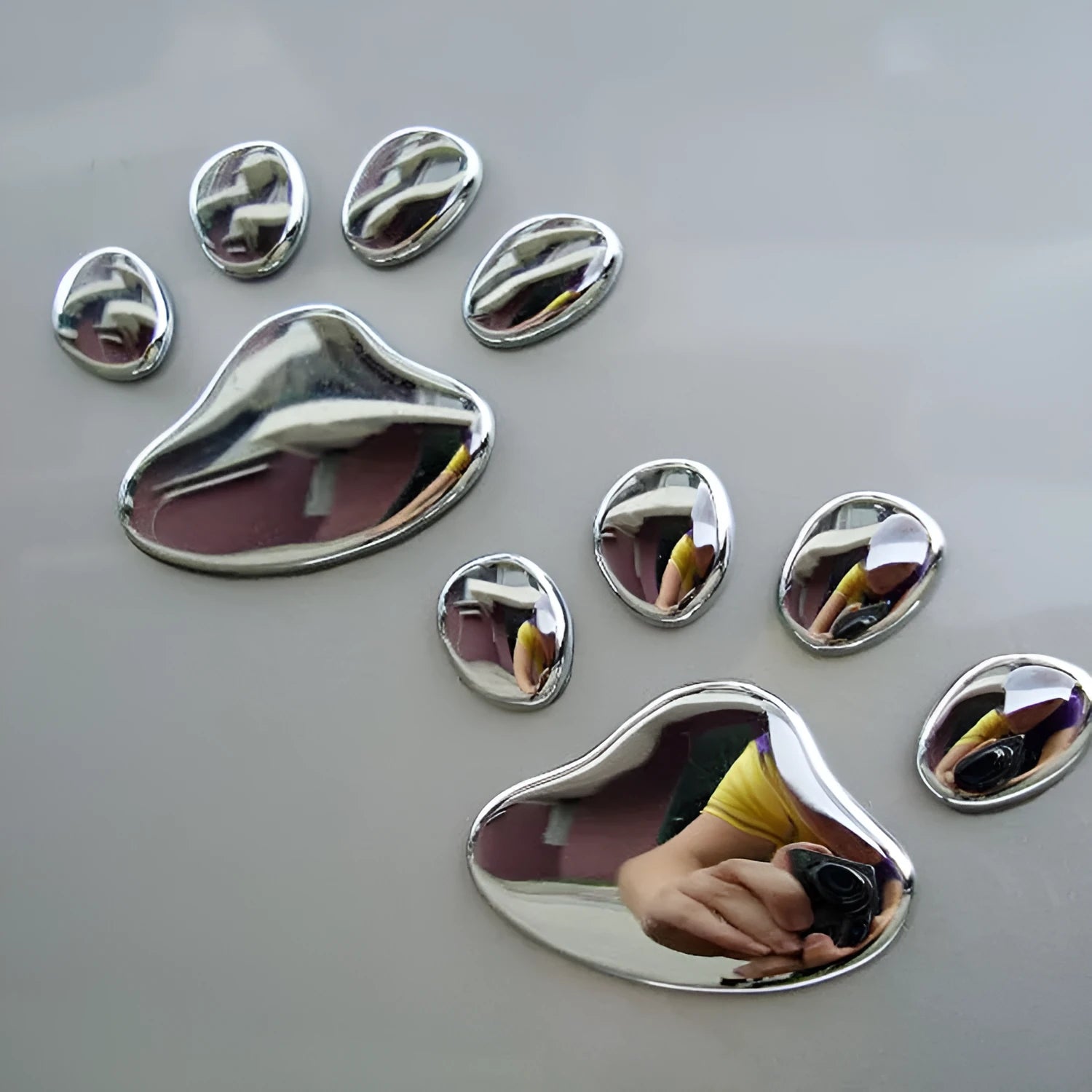 PVC car sticker with hand-shaped brush dog footprints design on a car bumper.