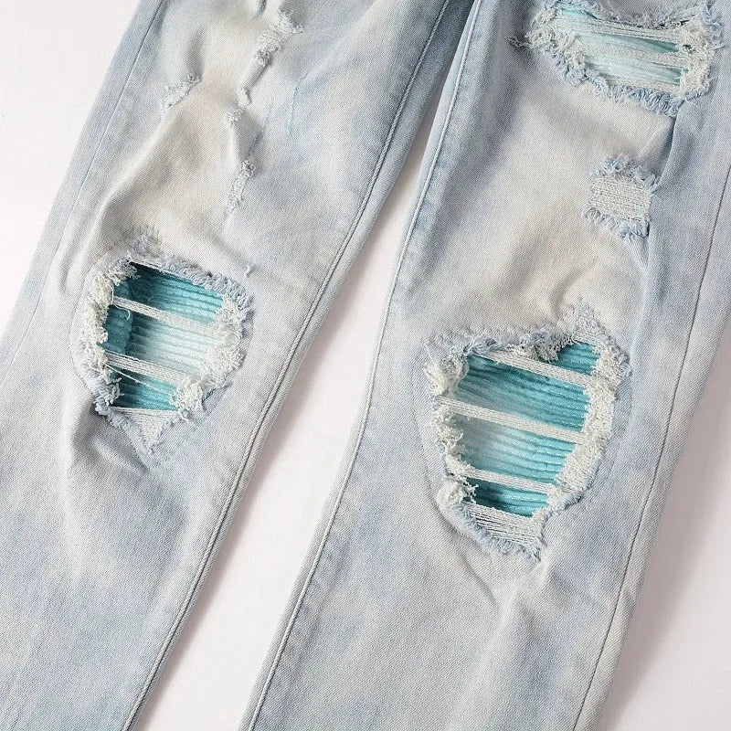 Men's light blue distressed slim fit jeans with five pocket patchwork, enzyme washed, side view