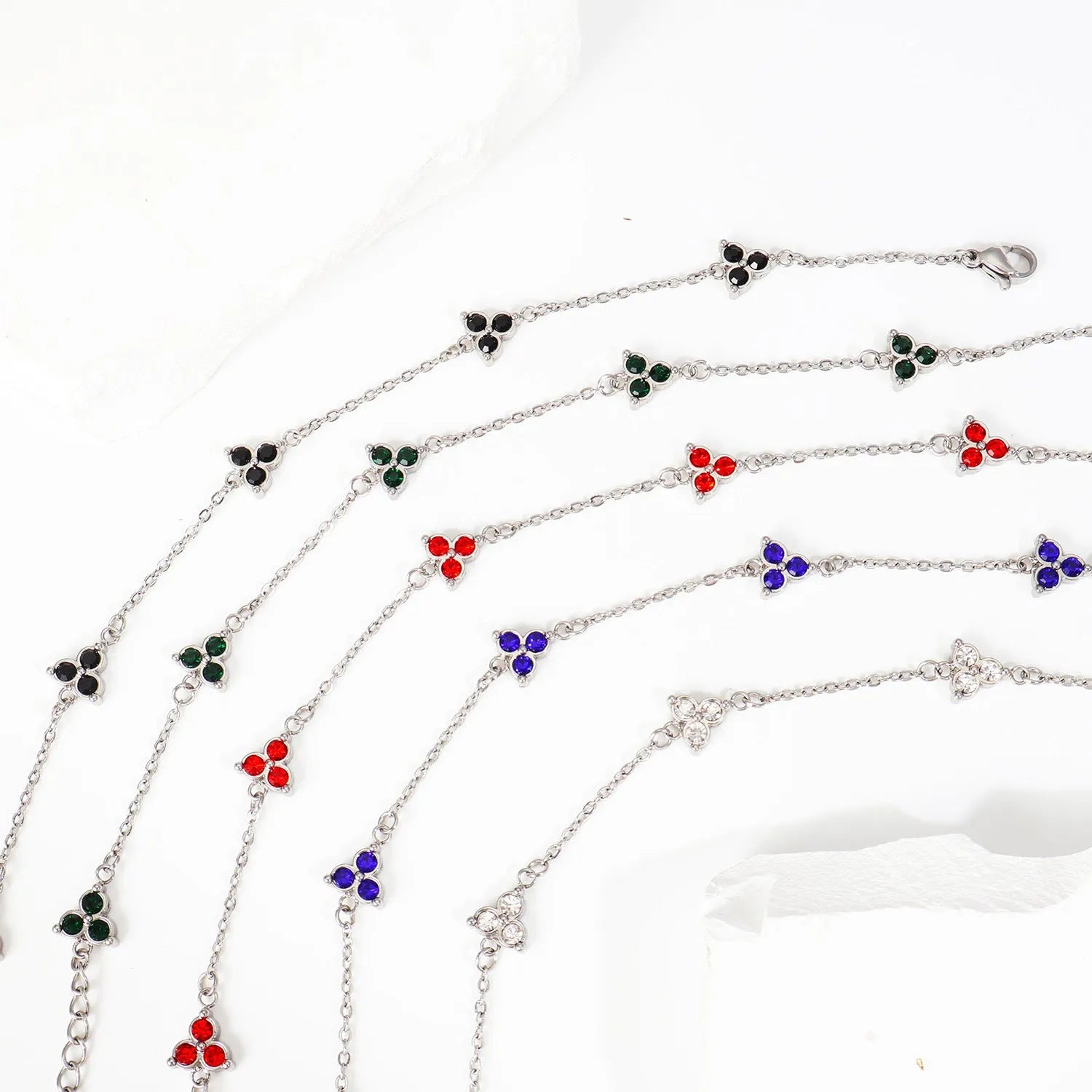 Geometric stainless steel women's bracelet with triangular links and a coloured stone centre.