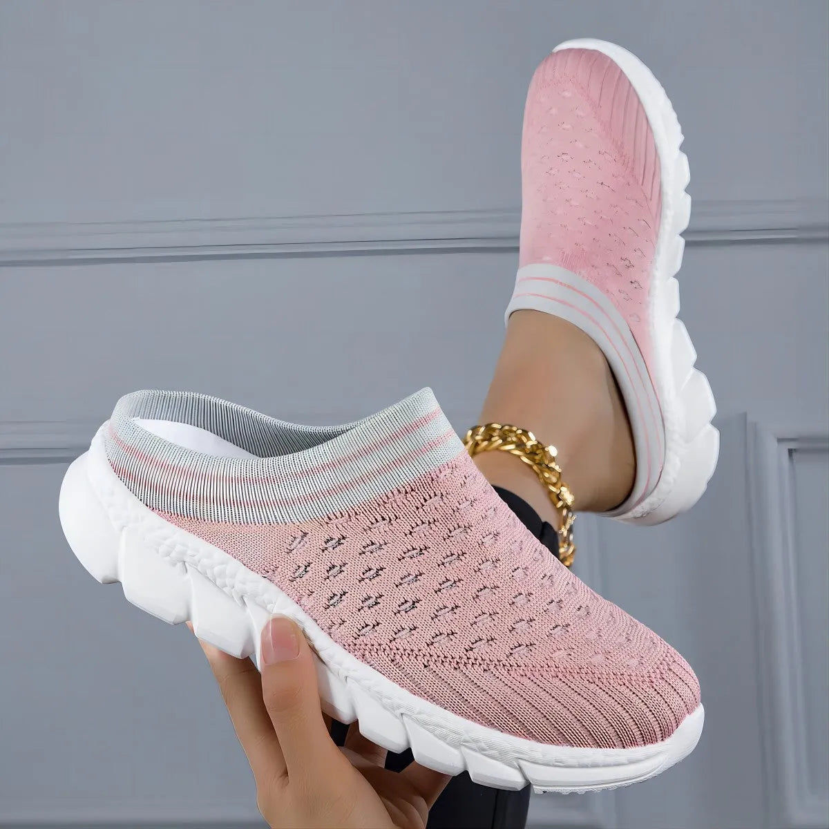 Black women's Flyknit sports slipper with hollowed-out pattern and striped design on a light background.