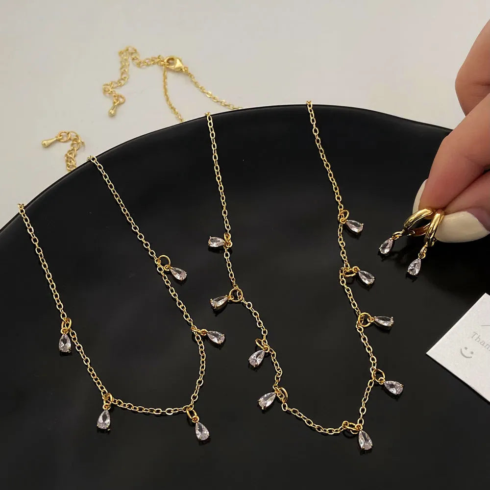 Women's zircon jewellery set showing geometric necklace, earrings, and anklet with meteor shower detail.