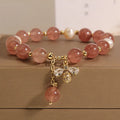 Women's bracelet with freshwater pearls, pink strawberry quartz stones, and a metallic zircon alloy clasp.