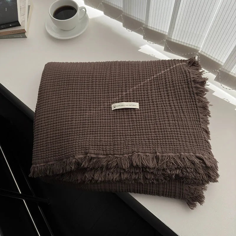 Four-layer gauze cotton blanket with tassel trim in a choice of ten colours and two sizes.