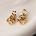 Geometric gold drop earrings with an irregular shape on a copper base.