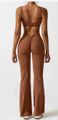 Woman wearing a black seamless yoga bodysuit with a hollow design detail and mid-waist fit.