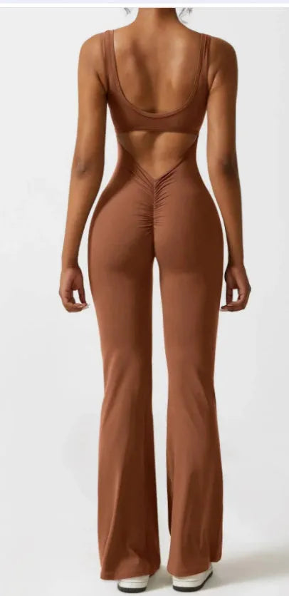 Woman wearing a black seamless yoga bodysuit with a hollow design detail and mid-waist fit.
