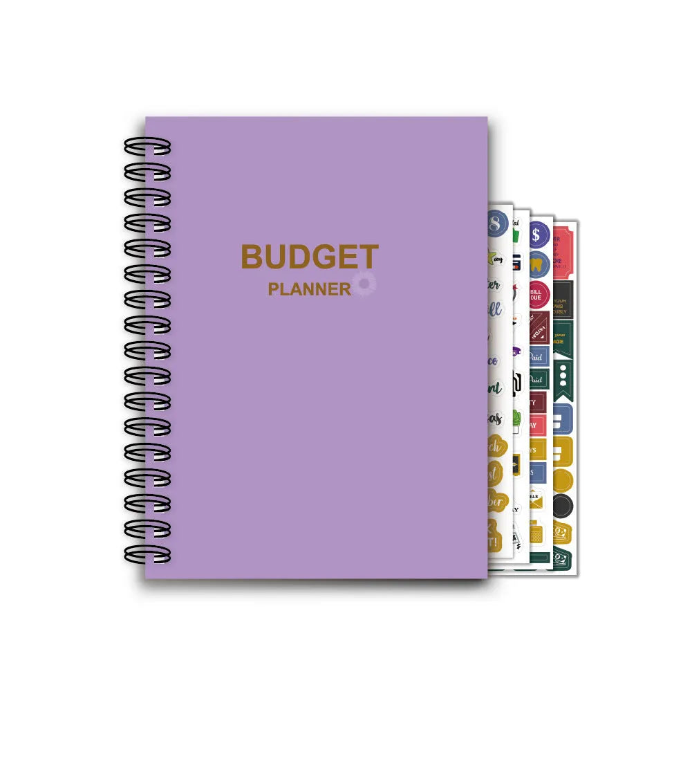 J12 Purple coil-bound monthly financial planning notebook with pen, stickers, and paper clips on a desk.
