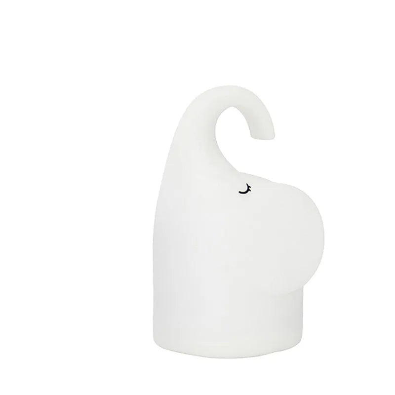 DOMI elephant-shaped silicone night light with warm white glow on a bedside table.