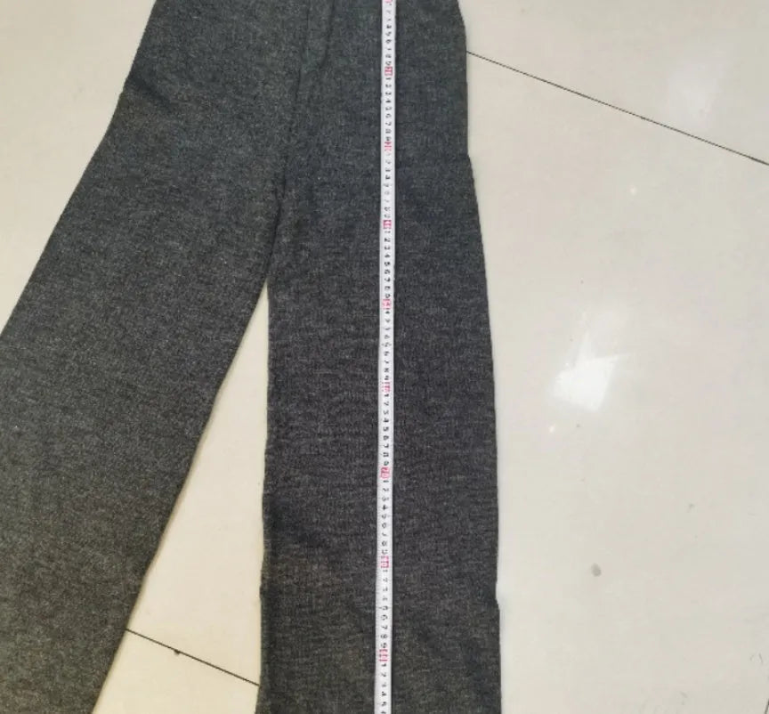 Women's dark grey acrylic knit sweater and trouser suit with a side-slit design on the top.