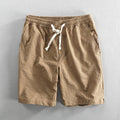 Men's striped casual shorts with elastic waistband in turmeric colour showing loose straight cut