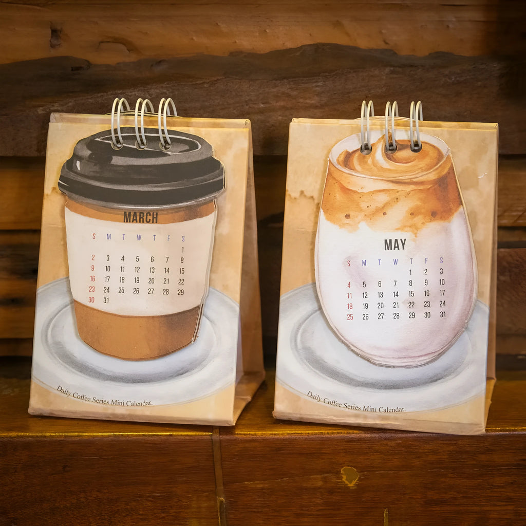 Mini coffee desk calendar 2025 with four design options on small desk surface