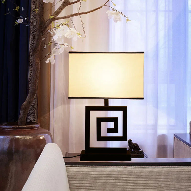Retro modern Chinese table lamp with fabric lampshade and iron base on wooden side table