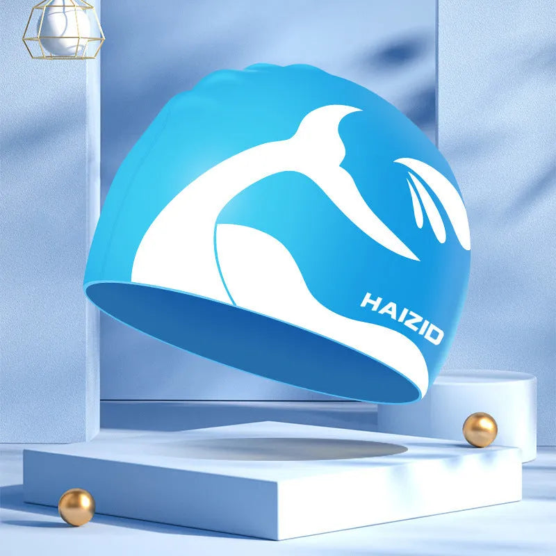Silicone swimming cap with whale tail pattern and moulded ear protectors in various colours.